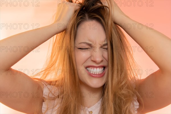 Stressed young woman with her hands in her hair
