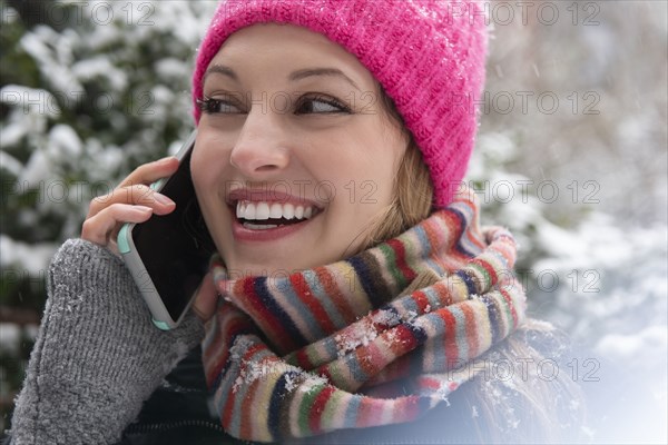 Young woman on phone call in snow