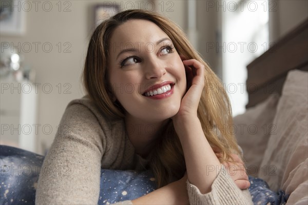 Young woman day dreaming on bed