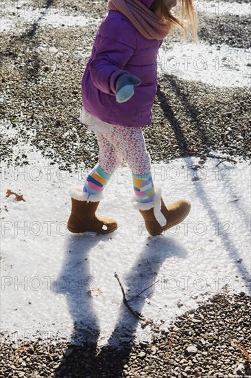 Girl wearing purple coat walking on snow