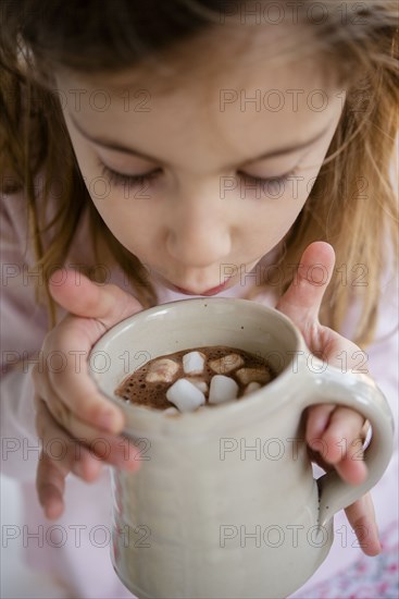 Girl blowing on hot chocolate