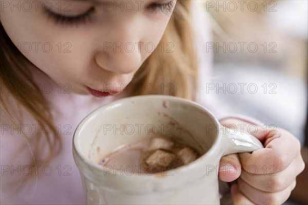 Girl blowing on hot chocolate