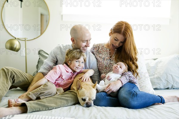 Family and their dog on bed