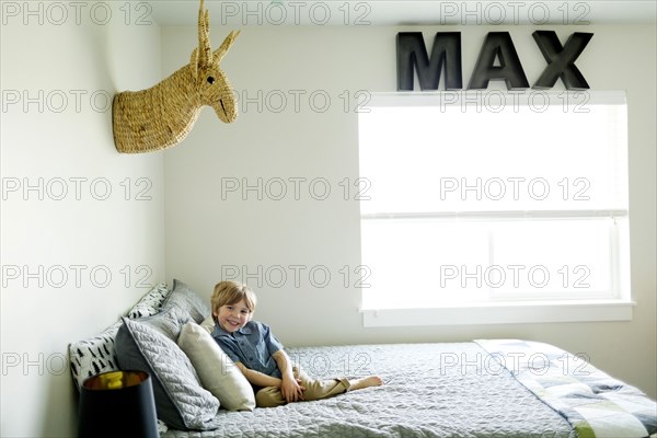 Boy sitting on his bed