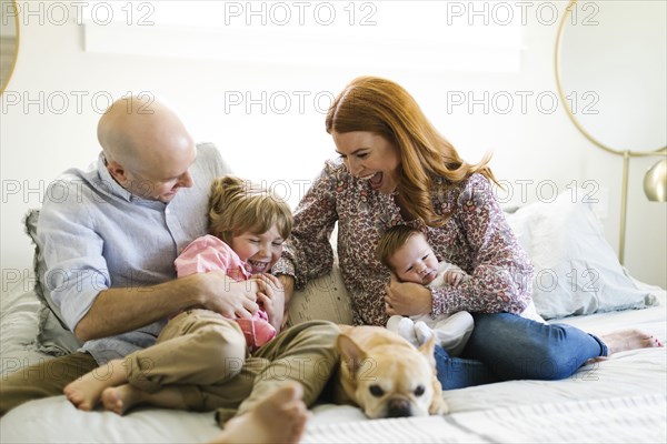 Family and their dog on bed