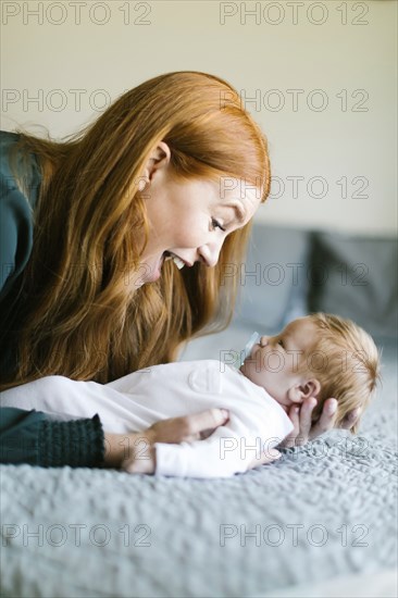 Woman holding her newborn son on bed