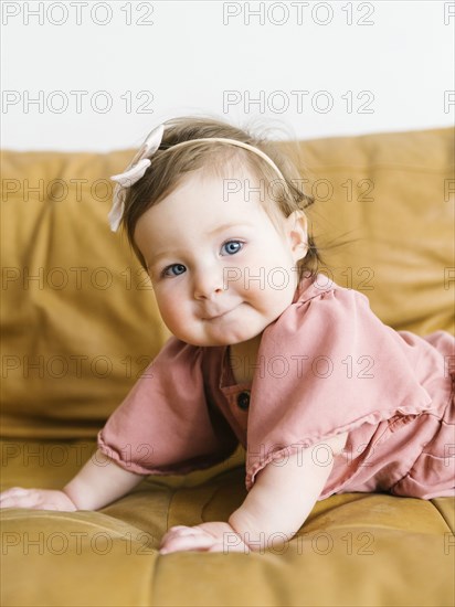 Baby girl lying on sofa