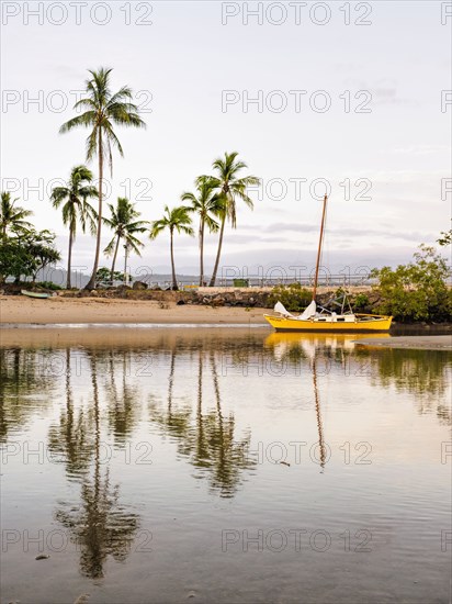 Yellow sailboat on beach in Port Douglas, Australia