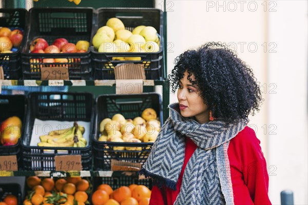 Young woman by crates of fruit