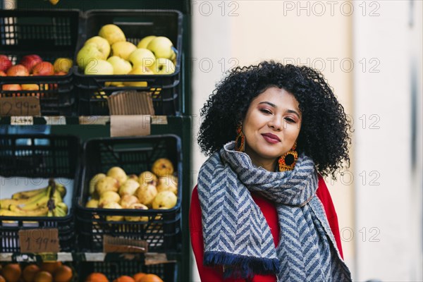 Young woman by crates of fruit