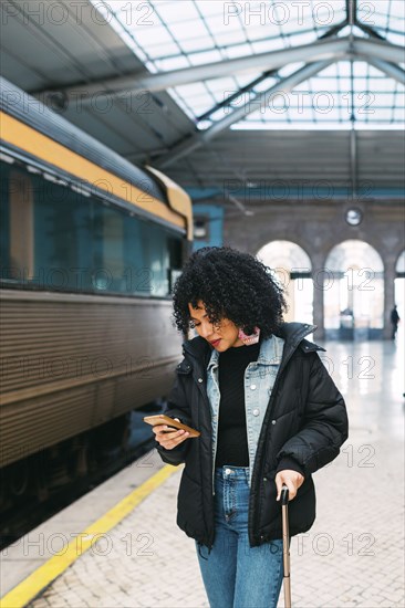 Young woman using smart phone in railway station