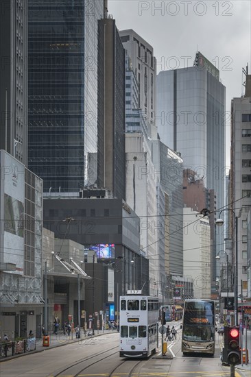 Double-decker tram and bus on street in Hong Kong, China