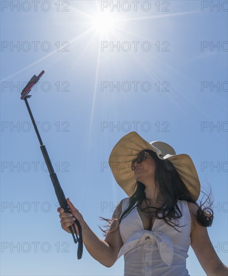 Low angle shot of woman using selfie stick