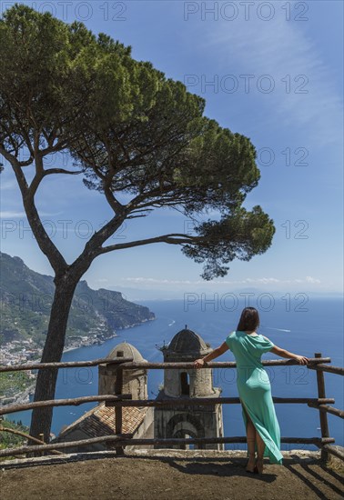 Woman leaning on fence by church in Ravello, Italy