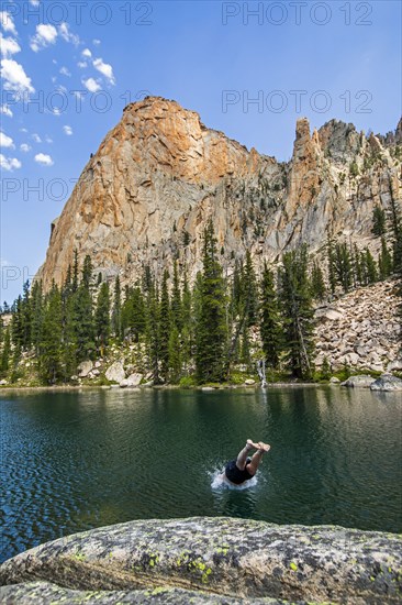 Man diving into lake by mountain in Stanley, Idaho, USA