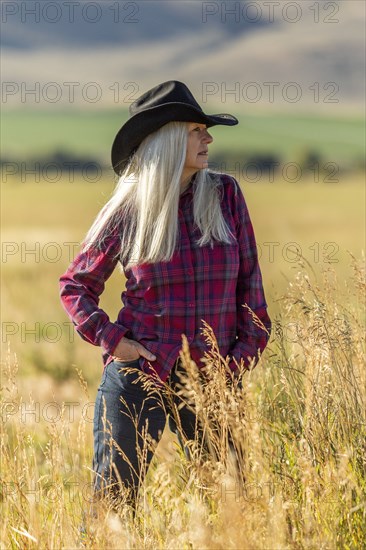 Mature woman wearing cowboy hat in field