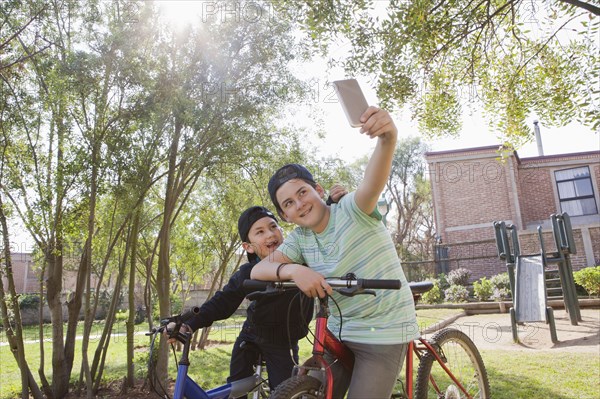 Brothers taking selfie on bicycles