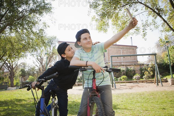 Brothers taking selfie on bicycles