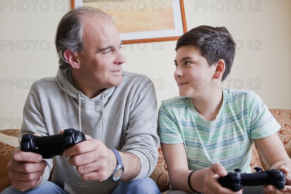 Father and teenage son playing video game