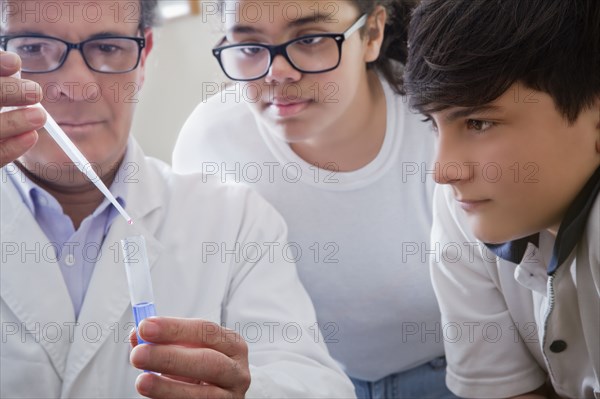 Science teacher showing students test tube experiment