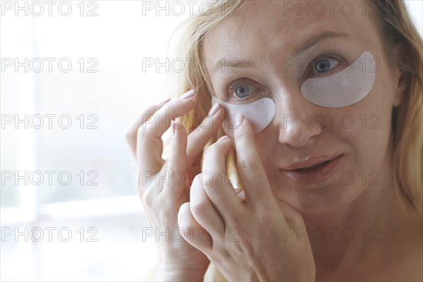 Woman applying under-eye mask