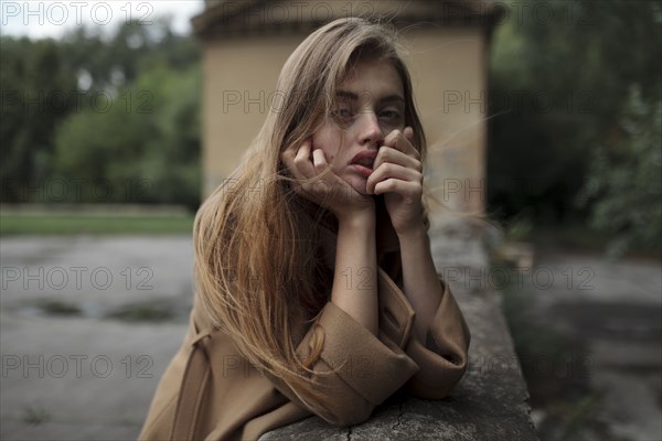 Young woman leaning on wall