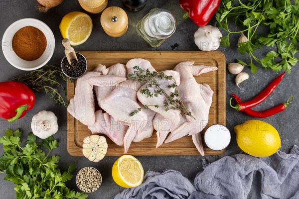 Raw chicken on cutting board surrounded by ingredients