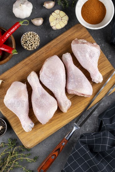 Raw chicken on cutting board surrounded by ingredients