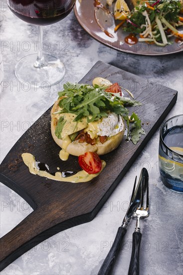 Eggs Benedict served on wooden cutting board