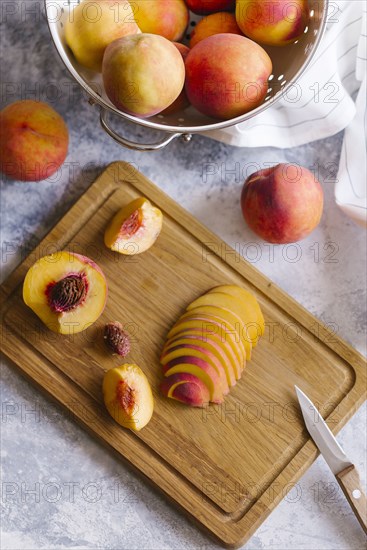 Peaches sliced on wooden cutting board