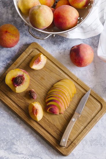 Peaches sliced on wooden cutting board