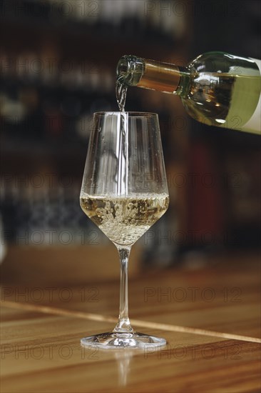 White wine poured from bottle into wineglass