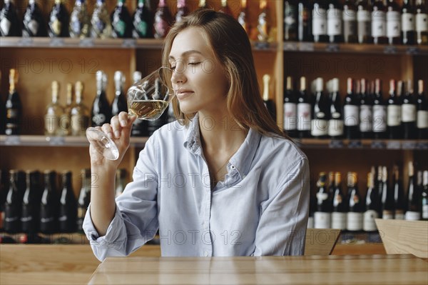 Young woman sniffing glass of white wine