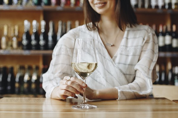 Woman holding glass of white wine