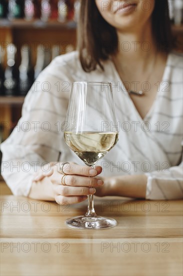 Woman holding glass of white wine