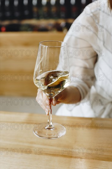 Hand of woman holding glass of white wine