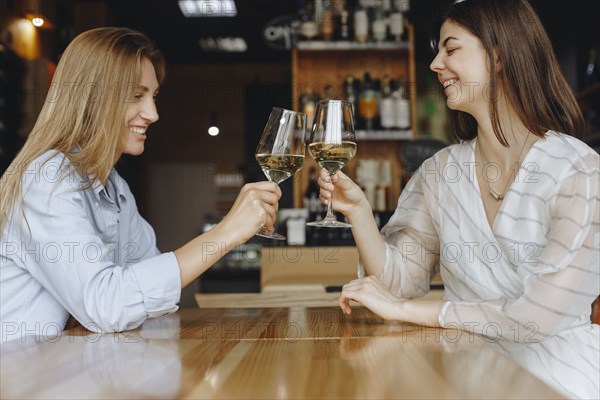 Young women toasting with glasses of white wine