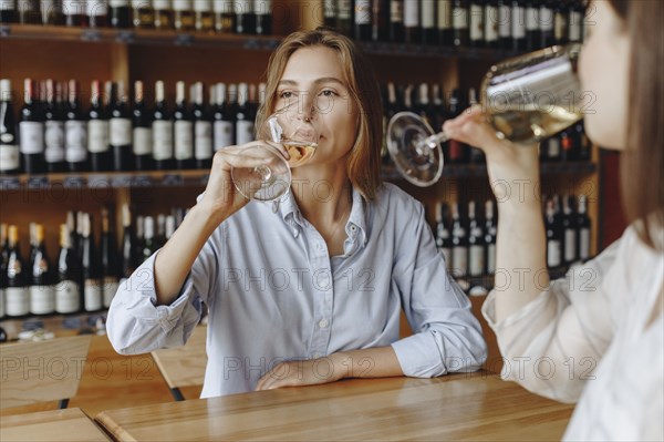 Young women drinking white wine