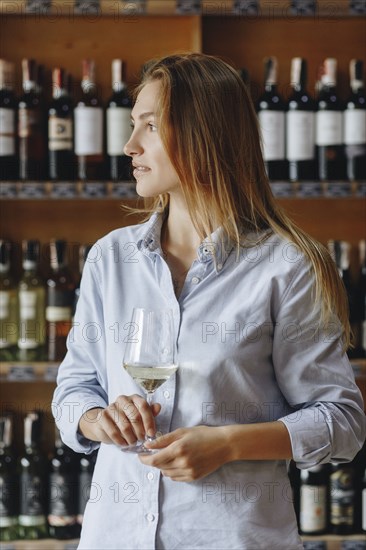 Young woman holding glass of white wine