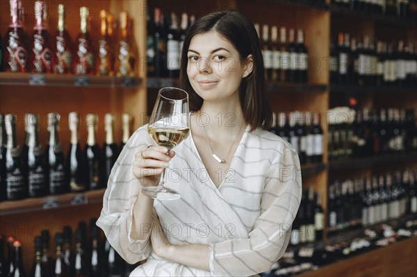 Young woman holding glass of white wine