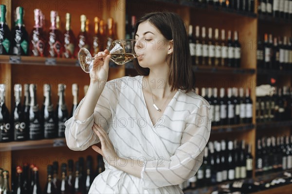 Young woman drinking white wine