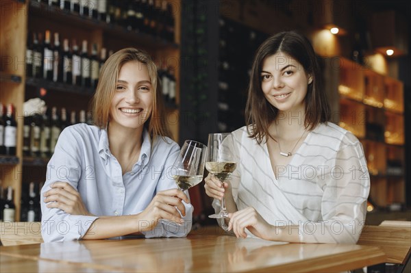 Young women toasting with glasses of white wine