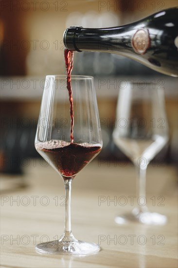 Red wine poured from bottle into wineglass