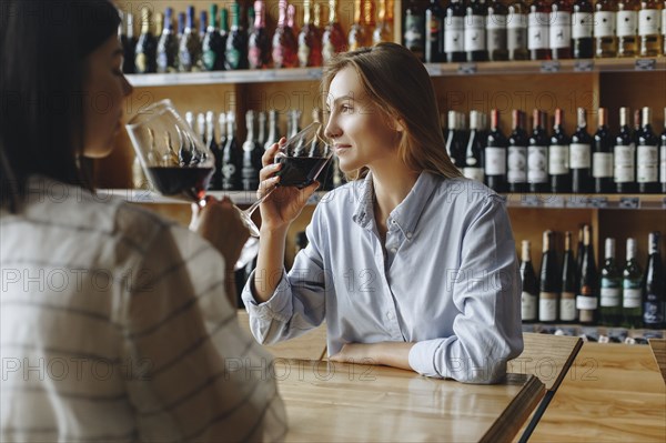 Young women drinking red wine