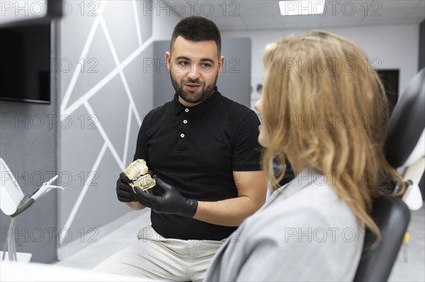 Dentist showing patient model teeth