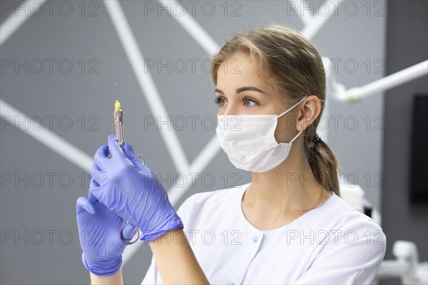 Dental assistant holding syringe