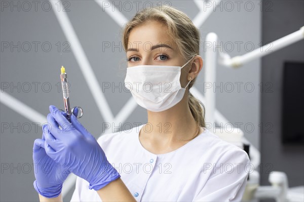 Dental assistant holding syringe