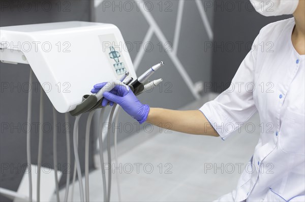 Dental assistant holding dental equipment