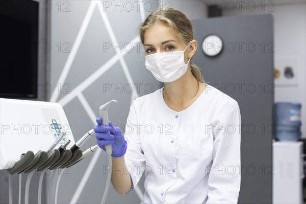 Dental assistant holding dental equipment