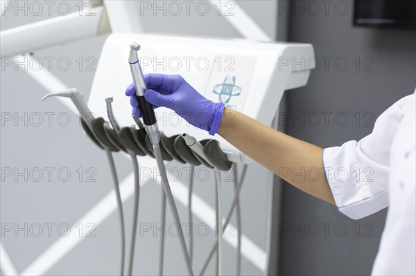 Dental assistant holding dental equipment